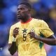 Thomas Partey running, wearing a yellow patterned Ghana shirt