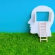 Human Head with Open Window and Ladder on Grass and Sky Backdrop