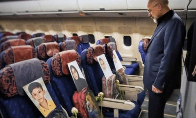 A man looks at photos of the children lost in the Minab tragedy in Iran