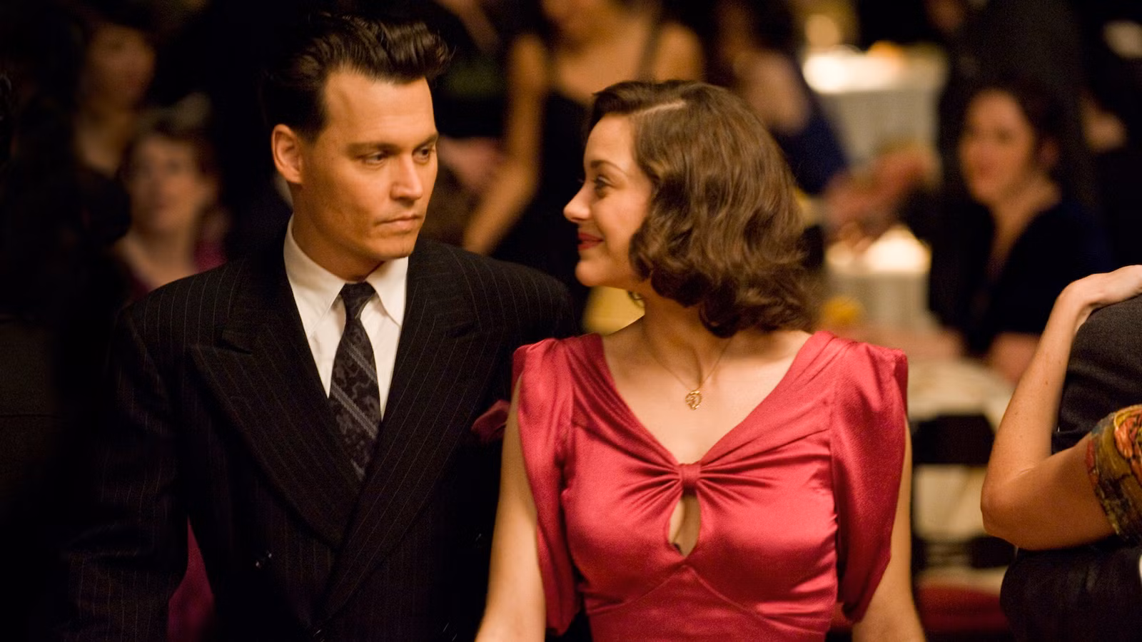 Johnny Depp and Marion Cotillard look at each other on the dance floor in Public Enemies.