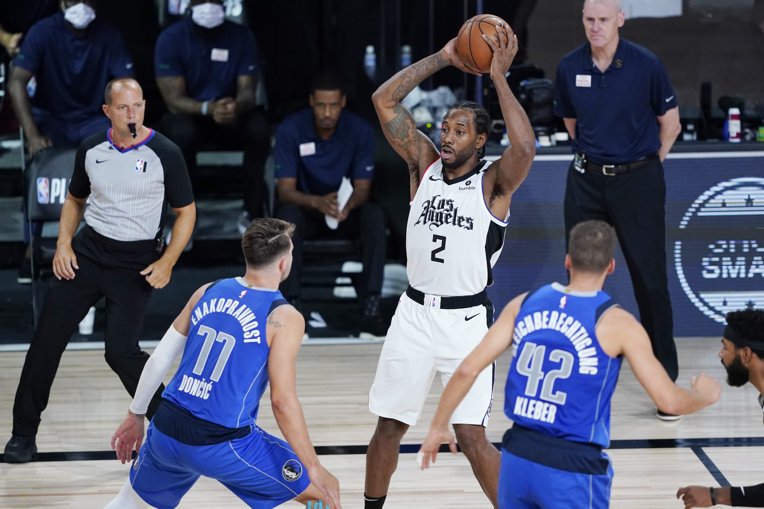 Kawhi Leonard #2 of the LA Clippers looks for help as he is defended by Luka Doncic #77 of the Dallas Mavericks and Maxi Kleber (42) during the second half of Game Three of the first round of the playoffs at the AdventHealth Arena at the ESPN Wide World O