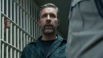 Paddy Considine walking into a jail cell in The Outsider.