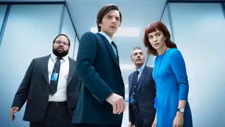 Four people in a hallway looking scared in Severance.