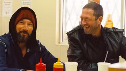 Jon Bernthal as Mikey sitting at a food counter next to Ebon Moss-Bachrach as Richie in