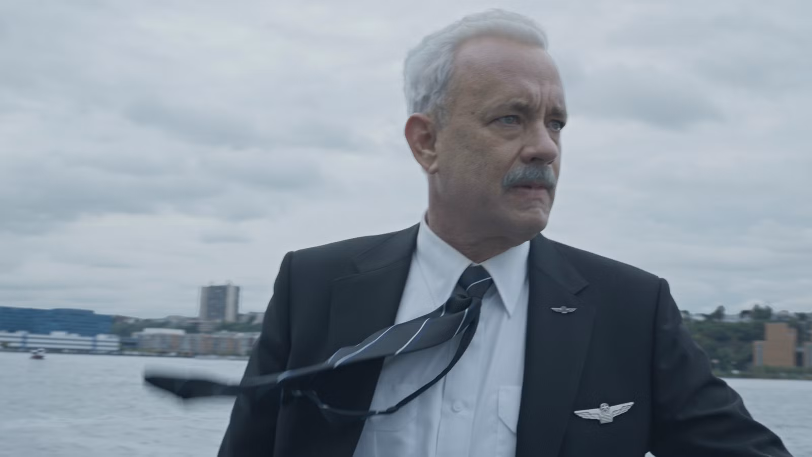 Sully (Tom Hanks) dramatically looking left with his tie blowing in the wind in Sully