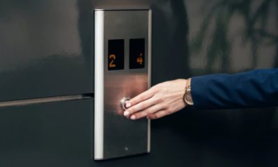 woman presses elevator button; she's on her way to a last minute meeting with the CEO or a very important client