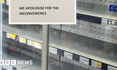 A supermarket fridge cabinet is empty. The shelves display the names of the items and prices which should be on them. A sign reads: 'Customer Notice. Due to the extreme temperatures some of our refrigeration and freezer units have broken down. Stock from these sections is unavailable at present. We apologise for the inconvenience.'