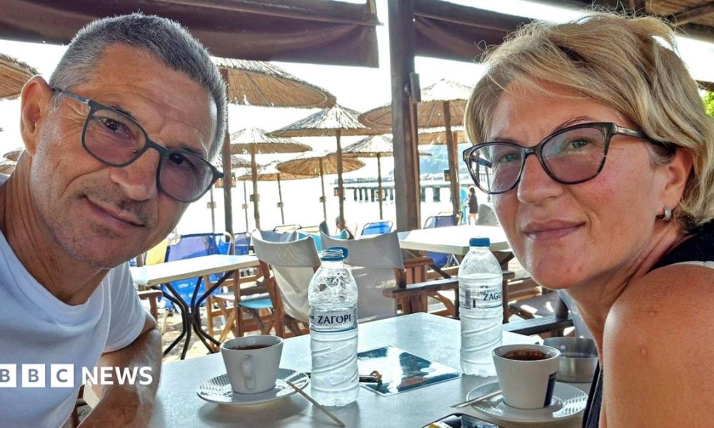 Karovic Ljubisa and his wife Svetlana Grković, smiling for a photo in a bar which appears to be at a holiday resort