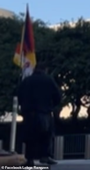 Palden Lobsang, 52, shared the video, capturing him walking to the street corner in Midtown Manhattan, carrying a Tibetan flag
