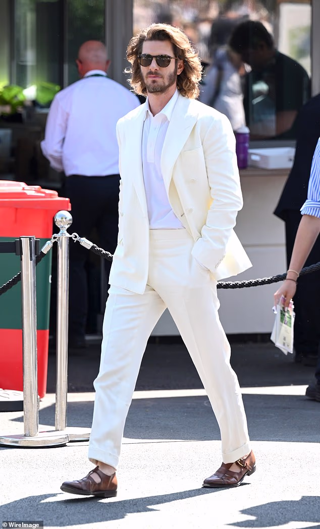 Andrew Garfield debuted his new wild long hair at Wimbledon on Sunday as fans exclaimed he looked 'almost unrecognisable'