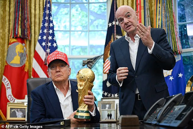 Donald Trump holds the World Cup trophy next to FIFA president Gianni Infantino