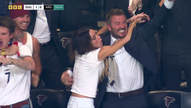 Victoria Beckham leaps into David's arms as she celebrates England's goal against Argentina after she became an instant meme for failing to react