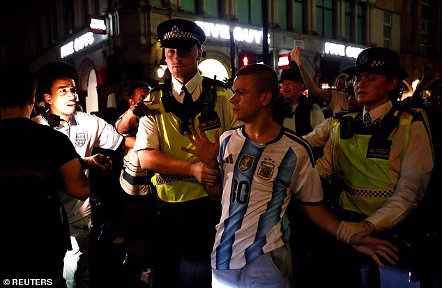 Police in London escort an Argentina fan away from England supporters following the final whistle