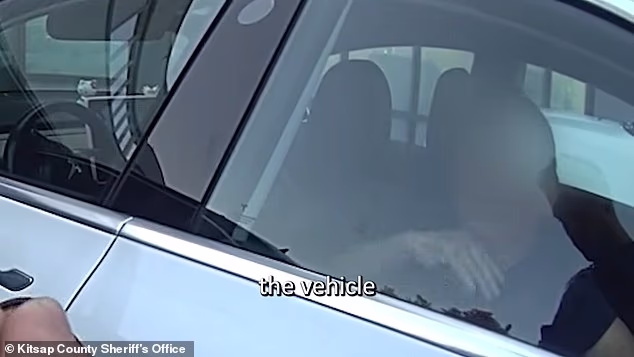 A grandmother in Washington State was rescued from a hot Tesla after she was trapped inside for more than an hour. She is pictured waving her hand in front of her face to show she was hot