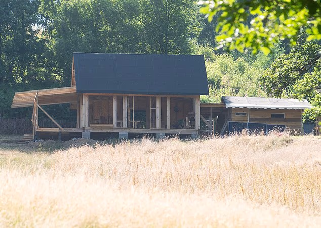 Members have partly built two wooden cabins on land they bought from a farmer in the village of Llanafan Fawr, Powys