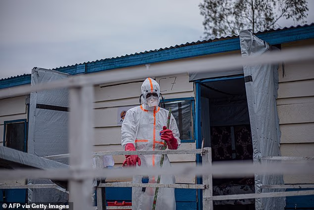 A hygienist is pictured cleaning and disinfecting at an Ebola Treatment Centre this week in DR Congo
