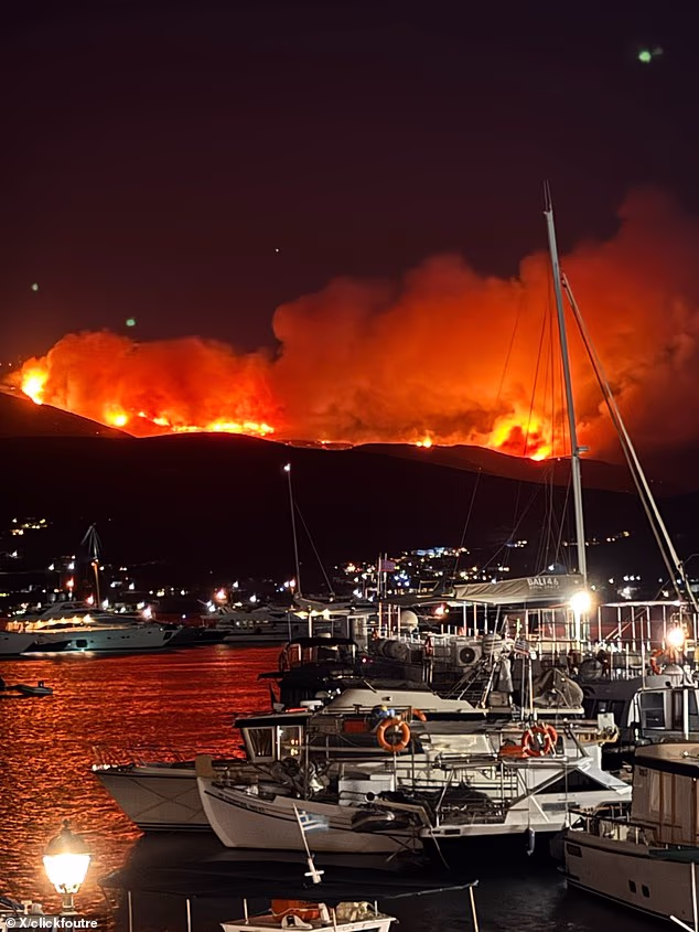 Footage shared on social media shows bright orange flames rising above the mountains as dark clouds of smoke engulf the island