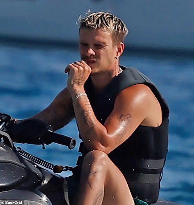 Romeo Beckham displayed his muscles as he enjoyed a solo jet ski ride during his family holiday to Ibiza on Thursday
