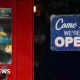 A red pub door with a 'Come in we're open' sign