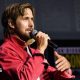 Ryan Gosling speaking into microphone on stage at San Diego Comic-Con