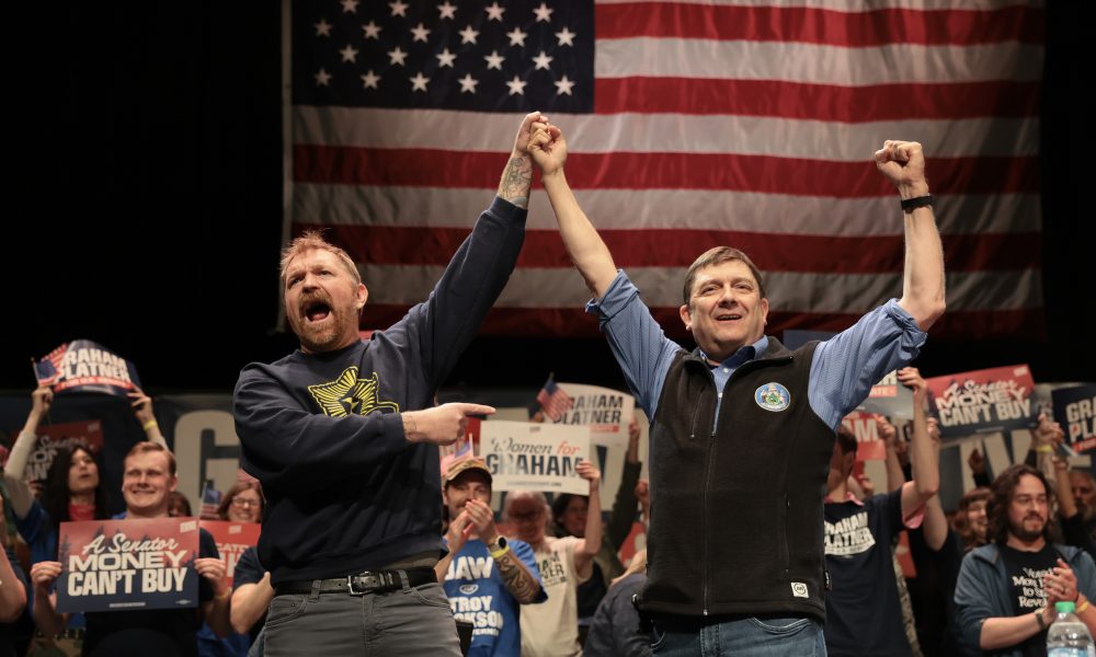 Graham Platner and Troy Jackson stand together during a “Fighting Oligarchy” tour stop on May 24, 2026, in Orono, Maine.