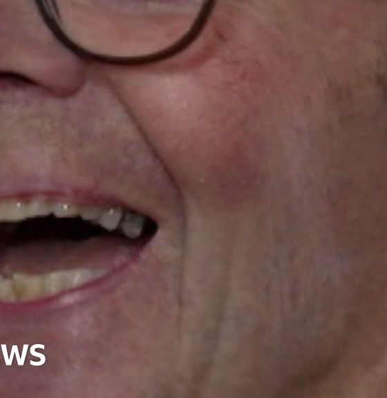 Patrick Meredith, he's a white man with glasses and grey hair. He's mid laugh, looking just away from the view of the camera.