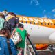 People climb the stairs onto an easyJet orange and white plane.