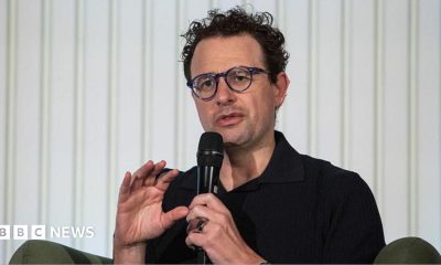 Anthropic chief executive Dario Amodei speaks through a microphone during a summit