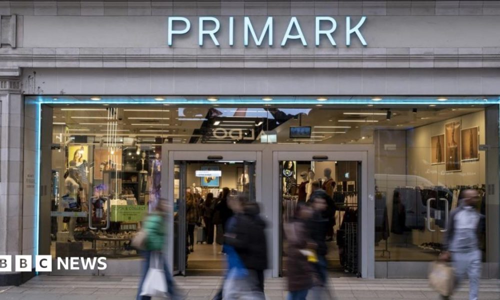 Shoppers, not in focus, walk past a Primark store in London