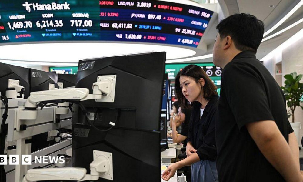 Currency dealers watch monitors as an electronic screen shows South Korea's benchmark stock index (KOSPI) in a foreign exchange dealing room at the Hana Bank headquarters in Seoul on July 28.