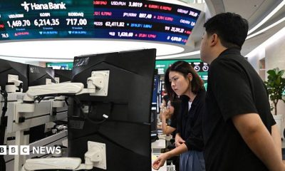 Currency dealers watch monitors as an electronic screen shows South Korea's benchmark stock index (KOSPI) in a foreign exchange dealing room at the Hana Bank headquarters in Seoul on July 28.