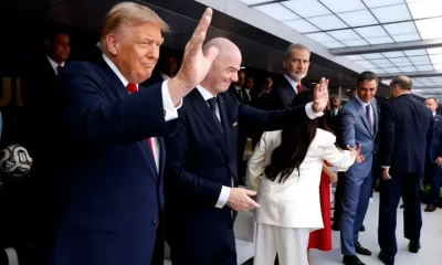 U.S. President Donald Trump waves at crowds with FIFA President Gianni Infantino during the FIFA World Cup 2026 Final on Sunday.