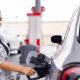 Woman wearing a grey shirt fills up her car at a gas station