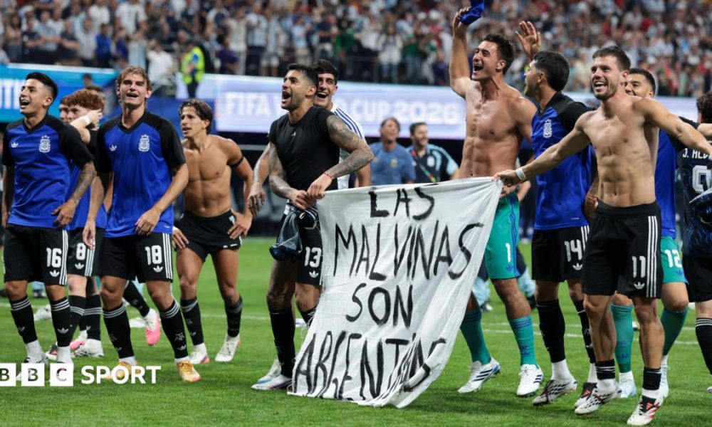 The Argentina players celebrate at full-time with a banner that reads "The Falkland Islands are Argentinian" during the World Cup 2026 semi-final between England and Argentina