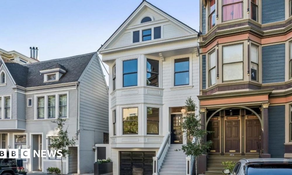 Three homes on a residential street in San Francisco. The three floor homes look clean and well maintained with well-trimmed plants and trees outside.