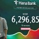 A man and a woman walk past an electronic screen showing 31 July's Kospi trading figures