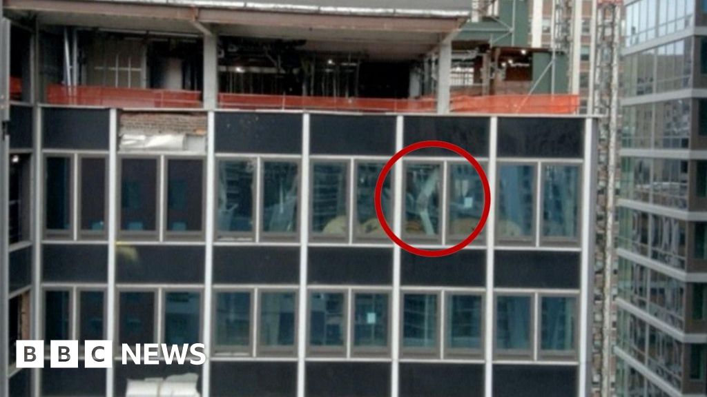 A NYC high-rise building has broken structural beams. In the image, one broken beam is circled in red.