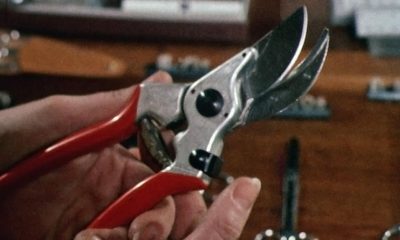Close up of a pair of left-handed secateurs with red handles.