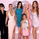 The Kardashian family is pictured posing in front of a pink background