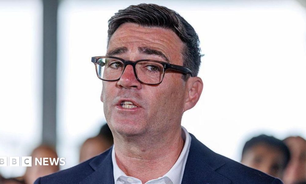 Andy Burnham in a suit and glasses. A close up of his face.
