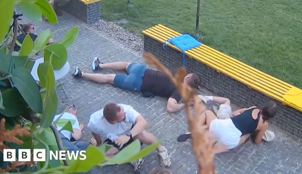 At least six people crouched on the floor as they take shelter from attack neaby