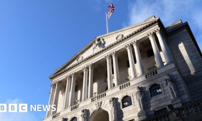 The front of the Bank of England building - a triangular roof is held up by multiple columns, and there is an arched entrance