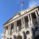 The front of the Bank of England building - a triangular roof is held up by multiple columns, and there is an arched entrance