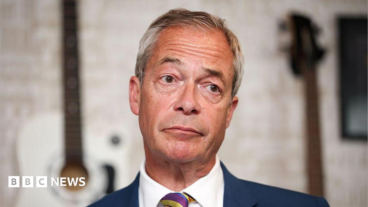 Nigel Farage in a close-up, wearing a blue suit, white shirt and stripe tie.