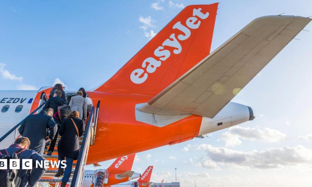 People climb steps onto an easyJet plane.