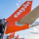People climb steps onto an easyJet plane.