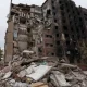 A concrete tower block in Ukraine damaged from an air strike from Russia with scorch marks on the side and rubble piled up on the ground