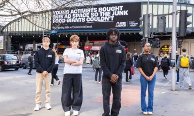 Bite Back campaigners in front of anti junk food ad on billboard