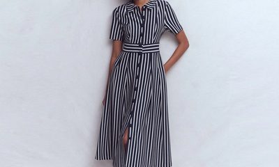 A woman wearing a navy-and-ivory striped shirtdress and black tall boots