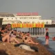 A banner hanging from Brighton pier reads Heat Strike Now as campaigners demand maximum working temperature